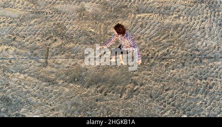 Vue aérienne au-dessus de l'homme en train de desserrer l'équilibrage sur la corde et de faire des acrobaties, démontrant l'agilité, Pacific Beach à San Diego, Californie, États-Unis Banque D'Images