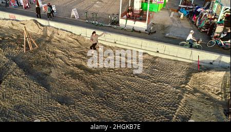 Vue aérienne au-dessus de l'équilibre mâle de la corde et de faire des acrobaties, à côté de la promenade sur Pacific Beach à San Diego, Californie, États-Unis Banque D'Images