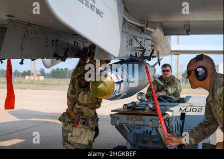 Des spécialistes des systèmes d'armement d'aéronefs affectés au 127e Groupe de maintenance, Garde nationale aérienne du Michigan, ont assuré le GBU-38 joint Direct Attack munition (JDAM) dans son rack à l'aéroport international Sawyer à Gwinn, dans la péninsule supérieure, au Michigan, le 3 août 2021. Une fois la bombe sécurisée, les troupes d'armes retiront le ruisseau rouge avant le vol afin que le pilote puisse utiliser l'ordonnance au besoin. Banque D'Images