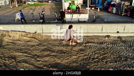 Vue aérienne au-dessus de l'équilibre mâle de la corde et de faire des acrobaties, à côté de la promenade sur Pacific Beach à San Diego, Californie, États-Unis Banque D'Images