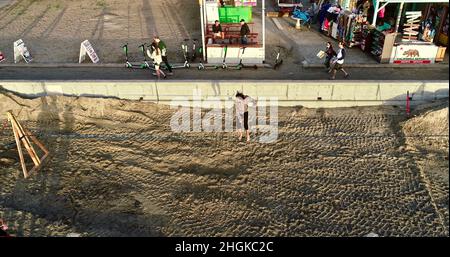 Vue aérienne au-dessus de l'équilibre mâle de la corde et de faire des acrobaties, à côté de la promenade sur Pacific Beach à San Diego, Californie, États-Unis Banque D'Images