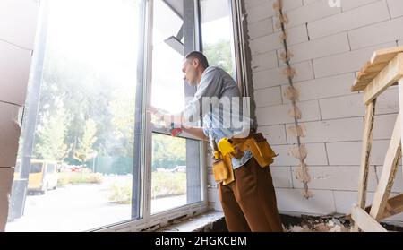 Travailleur de la construction de l'installation dans la fenêtre chambre Banque D'Images