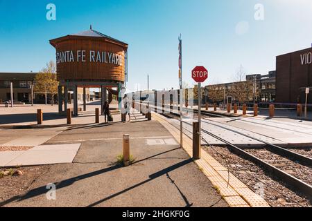 Un réservoir d'eau en bois avec les mots 'Santa Fe Railyard' à côté d'un passage à niveau de chemin de fer à Santa Fe, Nouveau-Mexique Banque D'Images