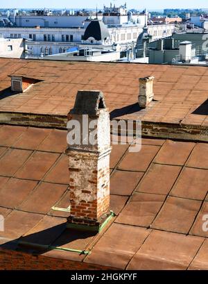 Cheminée sur le toit du bâtiment urbain.Cheminée traditionnelle en briques rouges, système d'aération sur le dessus de la maison.Vieux tuyaux de cheminée sur fond de toit moi Banque D'Images