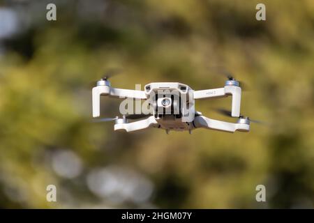 Kharkiv, Ukraine - 6 mars 2021 : DDJI Mavic Mini 2 drone, volant dans une forêt ensoleillée.Nouveau périphérique quadcopter stationnaire avec un arrière-plan de verdure flou Banque D'Images