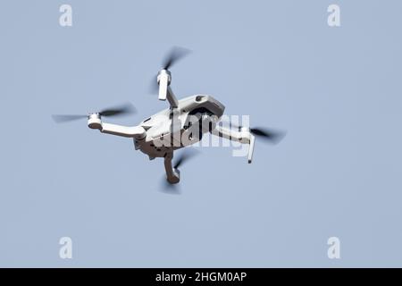 Kharkiv, Ukraine - 6 mars 2021: DDJI Mavic Mini 2 drone, volant dans la lumière du jour ensoleillée.Nouveau périphérique quadricoptère survolant un fond ciel clair Banque D'Images