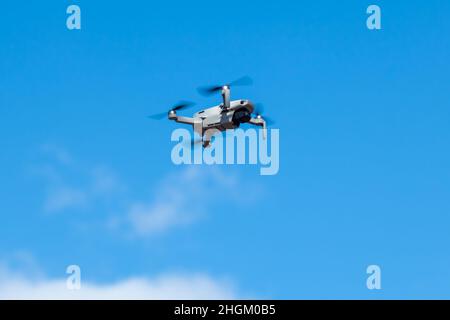 Kharkiv, Ukraine - 6 mars 2021 : DDJI Mavic Mini 2 drone, volant dans la lumière du jour bleue ensoleillée.Nouveau dispositif quadricoptère planant sur ciel nuageux et lumineux Banque D'Images