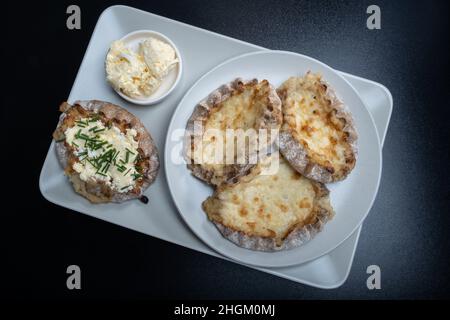 Helsinki / Finlande - 21 JANVIER 2022 : aliments traditionnels finlandais - tartes Karéliennes fraîches avec beurre d'œuf et ciboulette sur fond noir. Banque D'Images