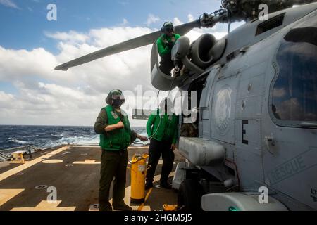 MER DE CHINE MÉRIDIONALE (JANV18, 2022) des marins effectuent des travaux d'entretien sur un hélicoptère MH-60R à bord du destroyer à missiles guidés de classe Arleigh Burke USS Ralph Johnson (DDG 114).Ralph Johnson est affecté à la Force opérationnelle 71/Escadrier Squadron (DESRON) 15, la plus importante force de surface déployée à l’avant de la Marine et la principale force de surface de la flotte américaine 7th.(É.-U.Photo de la marine par le spécialiste des communications de masse 2nd classe Samantha Oblander) Banque D'Images