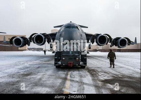 Des aviateurs affectés à l'escadron de maintenance des aéronefs 911th tracent un C-17 Globemaster III du hangar à deux baies sur la ligne de vol à la station de réserve aérienne de l'aéroport international de Pittsburgh, Pennsylvanie, le 20 janvier 2022.Le remorquage d'un aéronef exige qu'une équipe de plusieurs agents d'entretien repère, guide et relaie l'information pour s'assurer que l'aéronef se rend à la place de stationnement désignée en toute sécurité, sans aucun incident.(É.-U.Photo de la Force aérienne par Joshua J. Seybert) Banque D'Images