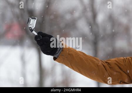 Homme prise de vue à la main par le petit appareil photo dans la neige profonde.Nature, tempête dans le parc urbain.Activités de plein air. Banque D'Images