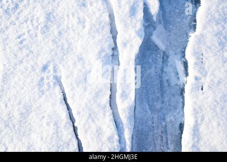 Des fissures de gros plan sur la glace recouverte de neige. Lac Baikal, Russie Banque D'Images