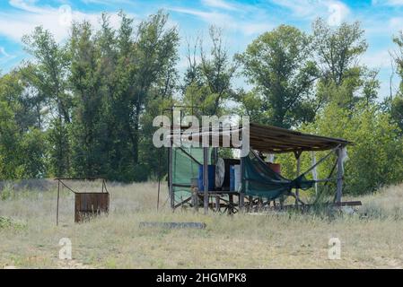 Barils de pétrole et de carburant sous hangar sur une ferme. Banque D'Images