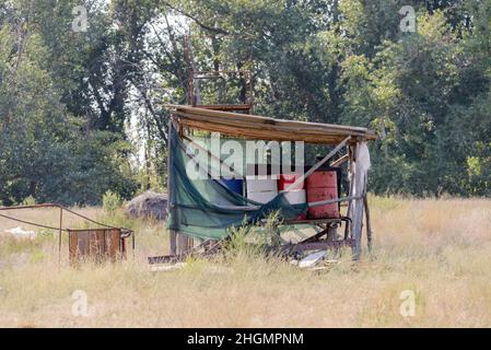 Barils de pétrole et de carburant sous hangar sur une ferme. Banque D'Images