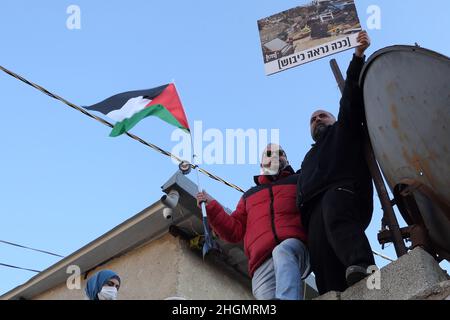 JÉRUSALEM, ISRAËL - JANVIER 21 : Ofer Cassif, le seul membre juif de la liste commune, une alliance de partis arabes dans la Knesset d'Israël, détient le drapeau palestinien et se tient avec des résidents palestiniens sur le toit d'une maison face à l'expulsion,Lors d'une manifestation organisée par des militants de gauche et des Palestiniens contre l'occupation israélienne et les activités de colonisation dans le quartier de Sheikh Jarrah le 21 janvier 2022 à Jérusalem, en Israël.Le quartier palestinien de Sheikh Jarrah est actuellement au centre d'un certain nombre de conflits de propriété entre Palestiniens et Israéliens juifs de droite.Un peu de hou Banque D'Images