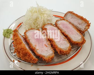 Tonkatsu, côtelette de porc panée et frite au Japon.Servi avec de la salade de chou et du wasabi. Banque D'Images