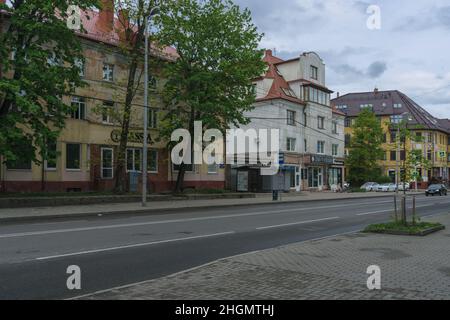 Kaliningrad, Russie - 16 mai 2021 : bâtiments typiques de faible hauteur avec route en face le jour sombre Banque D'Images