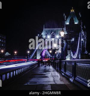 Des sentiers de signalisation passent au-dessus du Tower Bridge en début de soirée à Londres. Banque D'Images