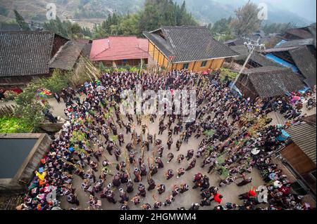 QIANDONGNAN, CHINE - le 21 JANVIER 2022 - photo aérienne prise le 21 janvier 2022 montre des membres ethniques miao qui exécutent une danse lusheng pour célébrer la végétation luxuriante Banque D'Images