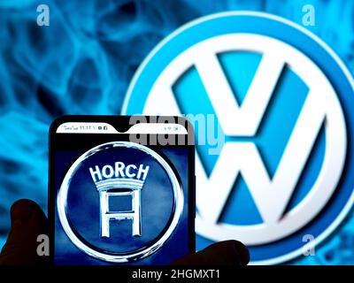 Dans cette illustration, le logo Horch AG est affiché sur l'écran d'un smartphone avec le logo Volkswagen AG en arrière-plan. Banque D'Images