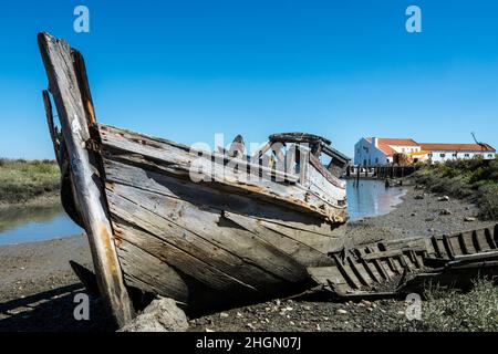 Épave d'un bateau de pêche en bois à la réserve naturelle de l'estuaire du Sado.Mourisca Watermill in the distance.Setubal, région de Lisbonne, Portugal Banque D'Images