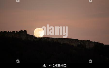 La pleine lune de janvier, connue sous le nom de Wolf Moon, s'élève au-dessus du mur-rideau du château de Scarborough.Le cycle lunaire régulier a été étudié par l'humanité Banque D'Images