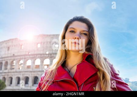 Jeune femme voyageant à Rome.Portrait de contre-jour d'une jeune femme blonde.La femme regarde dans l'appareil photo et porte une veste rouge.Dans le bac Banque D'Images