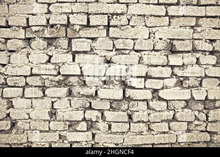 Mur en brique de maçonnerie rugueuse recouvert de chaux, fond texturé. Banque D'Images