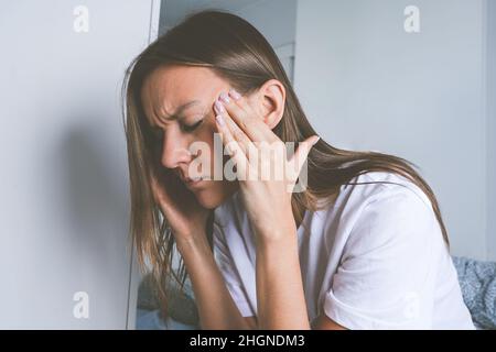 Jeune femme souffrant de douleurs à la tête, de maux de tête de tension, de migraine ou de dépression Banque D'Images