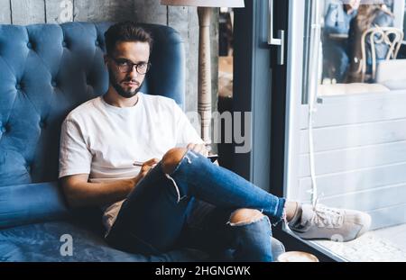 boxer millénaire dans des lunettes et des écouteurs optiques, qui passent du temps libre pour la planification Banque D'Images