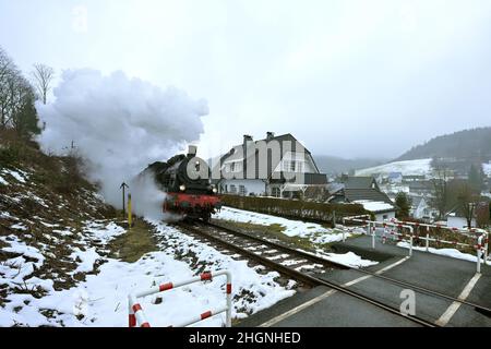 Winterberg, Allemagne.22nd janvier 2022.Un train historique traverse le village enneigé de Sauerland.La locomotive à vapeur historique est une Prusse T18 de 1920s.Sous le titre de "vapeur de toboggan au Sauerland", l'Association des amis ferroviaires de Bielefeld conduit une locomotive à vapeur historique de Bielefeld à Winterberg.A bord sont plusieurs centaines de fans de chemin de fer, qui toboggan sur les pistes avec leurs traîneaux à la destination.Le train s'arrête également à Paderborn, Lippstadt, Soest, Unna et Arnsberg, entre autres endroits.Credit: David Inderlied/dpa/Alay Live News Banque D'Images