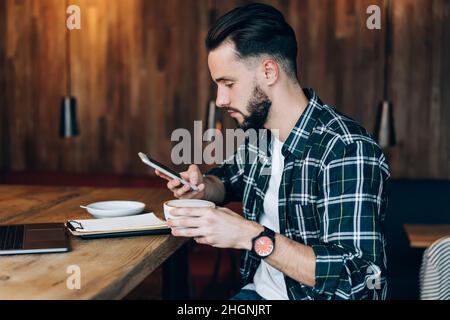 un jeune blogueur compétent vérifie la notification de smartphone Banque D'Images