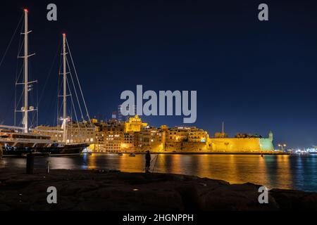 Vue sur la ville de Senglea la nuit à Malte, vue sur le Grand Port depuis la rive de Birgu. Banque D'Images