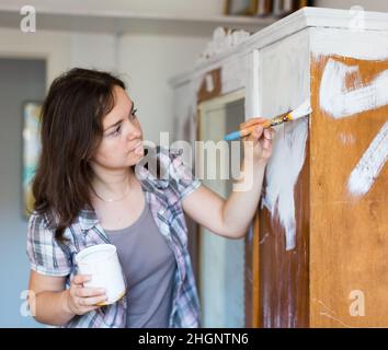 Femme fait des réparations dans l'appartement et peint placard Banque D'Images