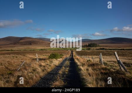 Bogroad au bord du parc national de Ballycroy avec de vastes tourbières et les montagnes des Nephin sauvages à l'horizon. Banque D'Images