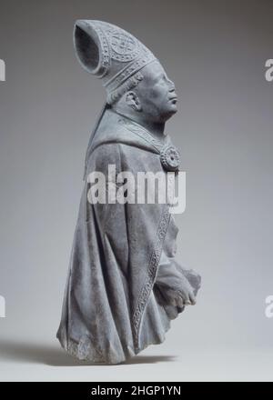 Soulagement d'un évêque ca.1400–1440 Netherlandish du Sud cette image de profil d'un évêque, sculptée dans le calcaire foncé caractéristique des basses-terres du Sud, est un fragment d'un relief funéraire plus grand.Bien qu'isolée de son contexte d'origine, la sculpture transmet encore la solennité du monument commémoratif.L'image a été sculptée à peu près au moment où l'atelier de Robert Campin, qui a créé le Triptych Annonciation dans cette galerie, produisait des œuvres séminales à Tournai, où un important groupe de sculptures de secours semblable à celle-ci est conservé dans la cathédrale.Soulagement d'un évêque.Donc Banque D'Images