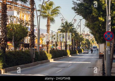 Manavgat, Turquie - 20 janvier 2022 : rue de la ville avec différentes maisons de faible hauteur, circulation active de voitures, magasins Banque D'Images