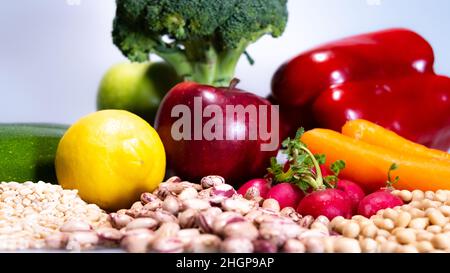 aliments végétaliens : haricots pinto, radis, carottes, pomme rouge et soja Banque D'Images