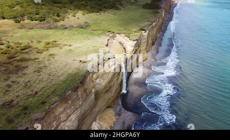 Cascade sur la falaise de Golovinsky sur l'île de Kunashir, îles Kuril, Russie.Photographie aérienne. Banque D'Images