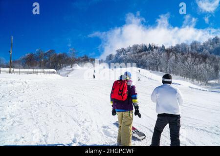 Deux snowboarders surfent en montagne. Snowboarders profitant des activités de loisirs en plein air. Groupe d'amis appréciant la saison d'hiver. Banque D'Images