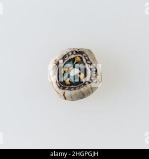 Inlay / perle blanc, motif floral 100 BC–100 AD période Ptoléméenne–période romaine Une technique de mosaïque de verre a permis de créer des multiples d'une image: Une composition figurale ou design a été faite en regroupant des cannes en verre de couleur, qui ont ensuite été tirées dans une longue barre.La barre a ensuite été sectionnée à angle droit, probablement en frappant la barre avec les outils appropriés, pour produire de petits carreaux incrusts.Le carreau serait alors lissé et poli sur la face destinée à apparaître vers l'extérieur.Incrustation / perles, motif fleuri.100 BC–100 AD.Verre.Période Ptolemaic–période romaine.De l'Égypte Banque D'Images