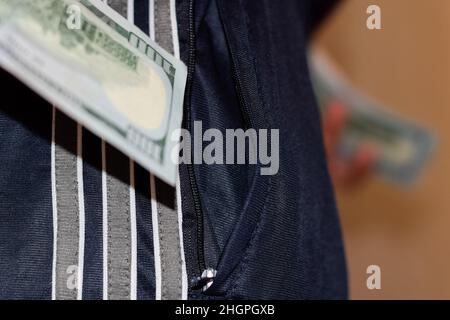 Un sac d'argent dans la poche du pantalon d'un homme.Des dollars dans votre poche. Banque D'Images