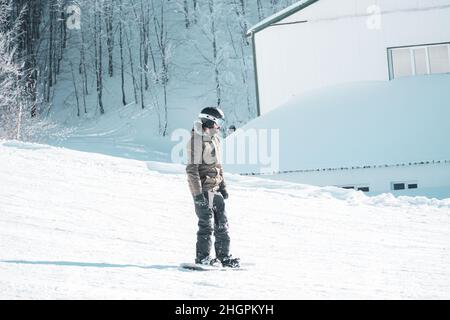 Homme dans des vêtements chauds snowboard freestyle de descente.Sports d'hiver.Sports extrêmes en hiver.Snowboardeur pour les sports extrêmes. Banque D'Images