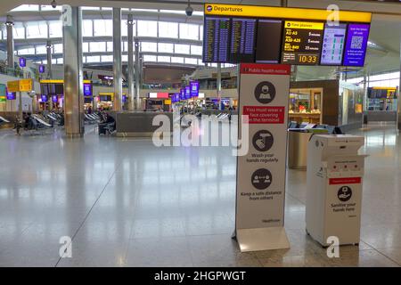 Aéroport international de Heathrow, Londres, Royaume-Uni - Mai 8 2021 : peu de passagers attendent à la porte avec en premier plan le panneau de signe de distance sociale sur Banque D'Images