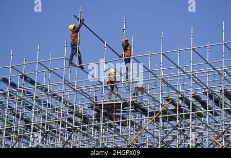 On voit des ouvriers travailler sur un échafaudage sur le chantier de construction de routes côtières à Mumbai.Le projet de route côtière est une autoroute à huit voies qui reliera la partie sud de la ville à l'extrémité nord Banque D'Images