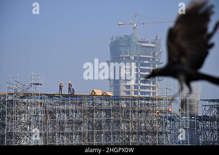 On voit des ouvriers travailler sur un échafaudage sur le chantier de construction de routes côtières à Mumbai.Le projet de route côtière est une autoroute à huit voies qui reliera la partie sud de la ville à l'extrémité nord Banque D'Images