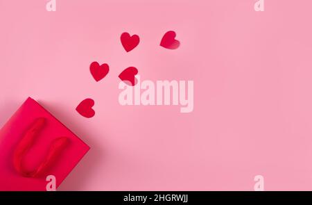 Concept d'achat en ligne.Vue de dessus du sac cadeau et des coeurs en papier rose Banque D'Images