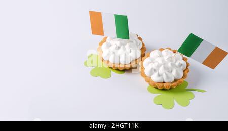 Tartes à la crème et drapeaux d'Irlande sur fond blanc.Saint Patrick's Day, 17 mars, espace de copie Banque D'Images