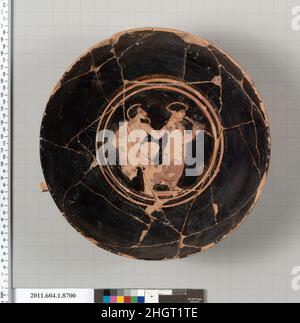 kylix sans tige en terre cuite (coupe à boire) 430–420 C.-B. grec, intérieur Attique, sur l'exergue; homme barbu avec sa himature drapé sur son dos, approchant une femme de derrière, avec sa main droite reposant sur son épaule droite; la femme porte un chiton et joue les aulos;Extérieur, l'arrière et l'arrière sont décorés avec un motif de losange; chaque losange vitré et réservé a un point dessiné en glaçure noire; sous chaque poignée, en silhouette, un quadripôle à droite.kylix sans pied en terre cuite (tasse à boire).Grec, Attique.430–420 C.-B.Terre cuite, figure rouge.Classique.Vases Banque D'Images