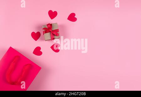Concept d'achat en ligne.Vue de dessus du sac cadeau et des coeurs en papier rose Banque D'Images